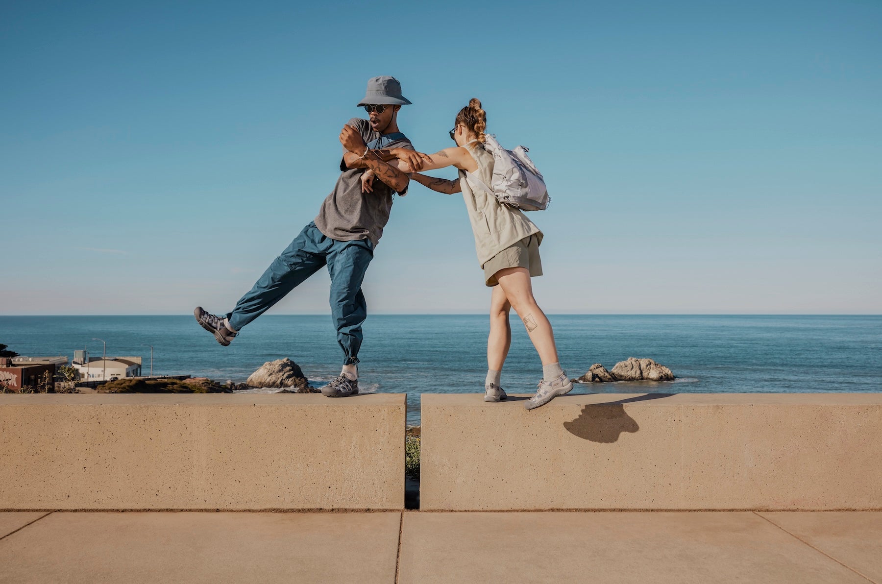 Couple wearing Newport balancing on a wall