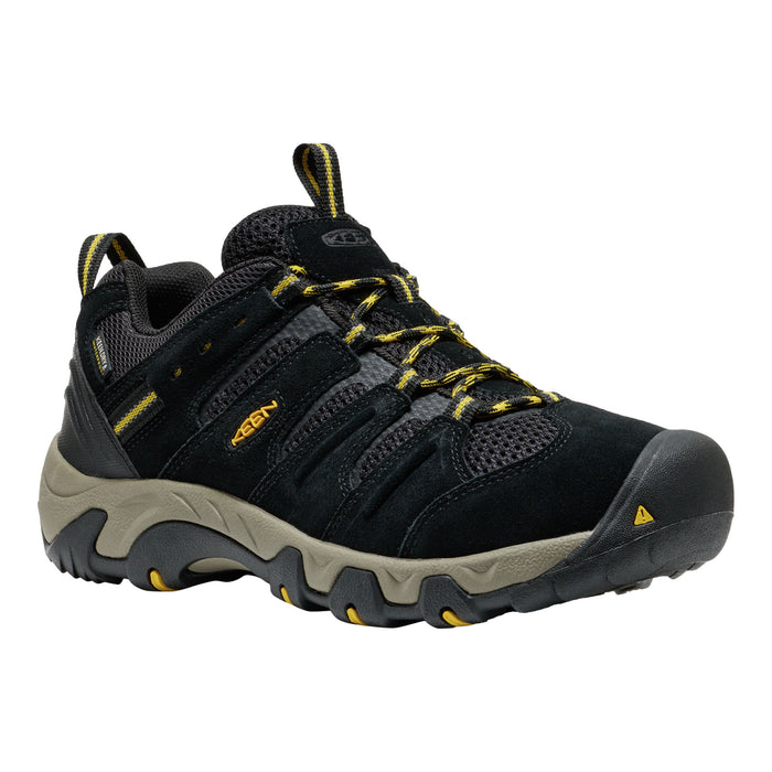 Black hiking shoe with yellow accents on a white background