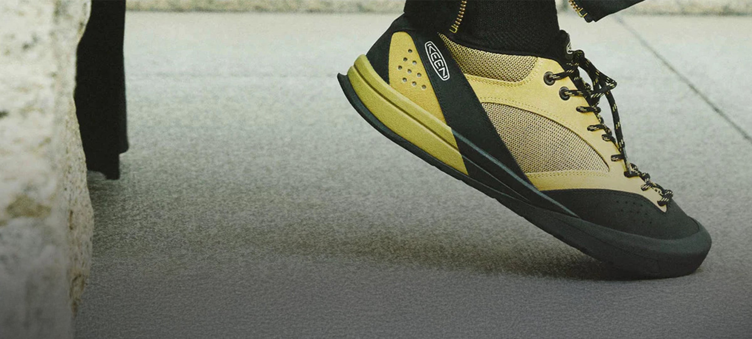 Yellow and black climbing shoe on a concrete floor