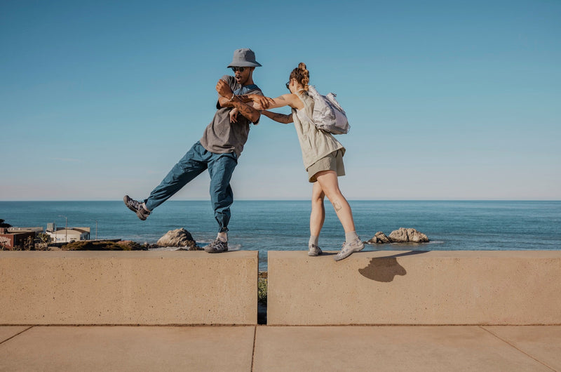 Couple wearing Newport balancing on a wall