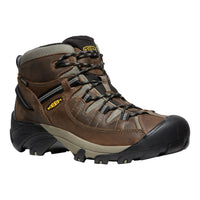 Brown hiking boot with black sole on a white background