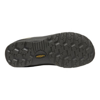 The treaded black rubber outsole of a Keen shoe, featuring a yellow and black Keen logo in the center, shown against a plain white background.