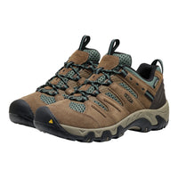 A pair of Keen outdoor hiking shoes in brown suede and green mesh, featuring dark laces, a black toe cap, and a beige midsole, shown against a plain white background.