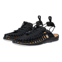 Black sandals with woven straps on a white background