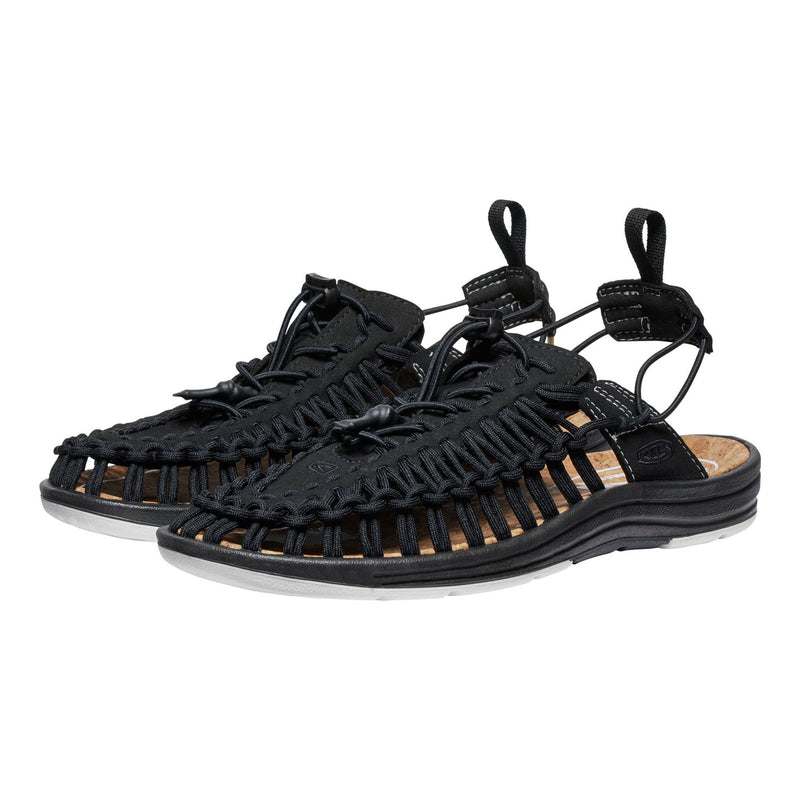 Black sandals with woven straps on a white background