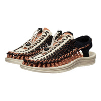 Pair of woven sandals with brown and black straps on a white background