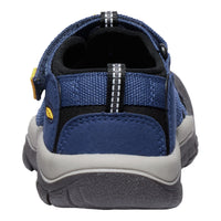 A close-up rear view of a blue and gray slip-on shoe with a textured fabric upper, black lining, and a gray and black sole, shown on a white background.