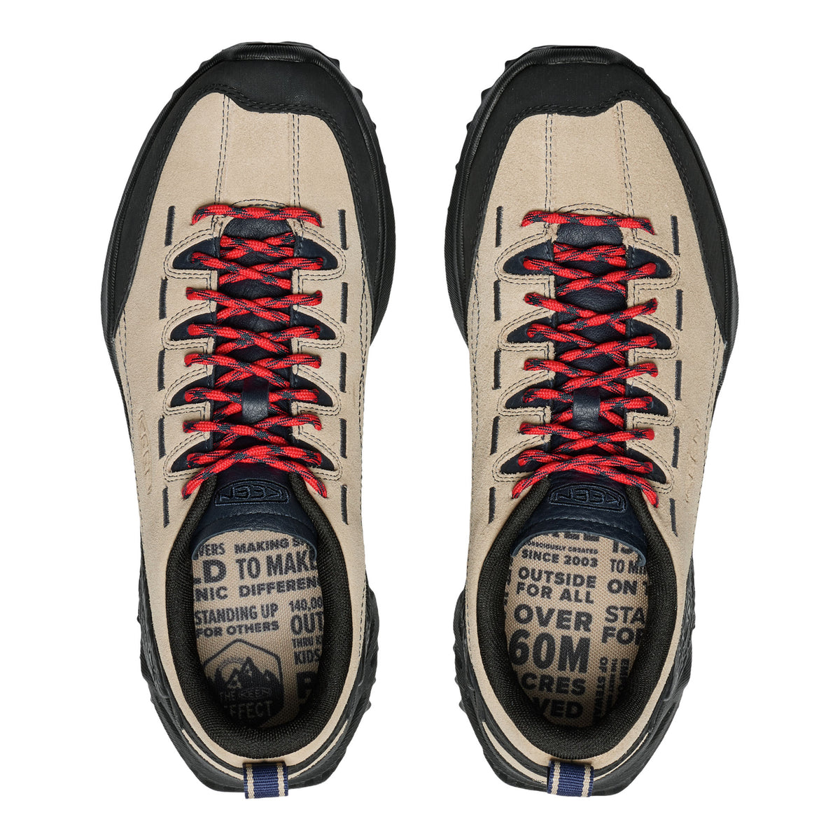 Pair of beige hiking shoes with red and black laces on a white background