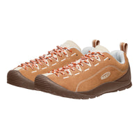 Pair of brown hiking shoes with orange laces on a white background