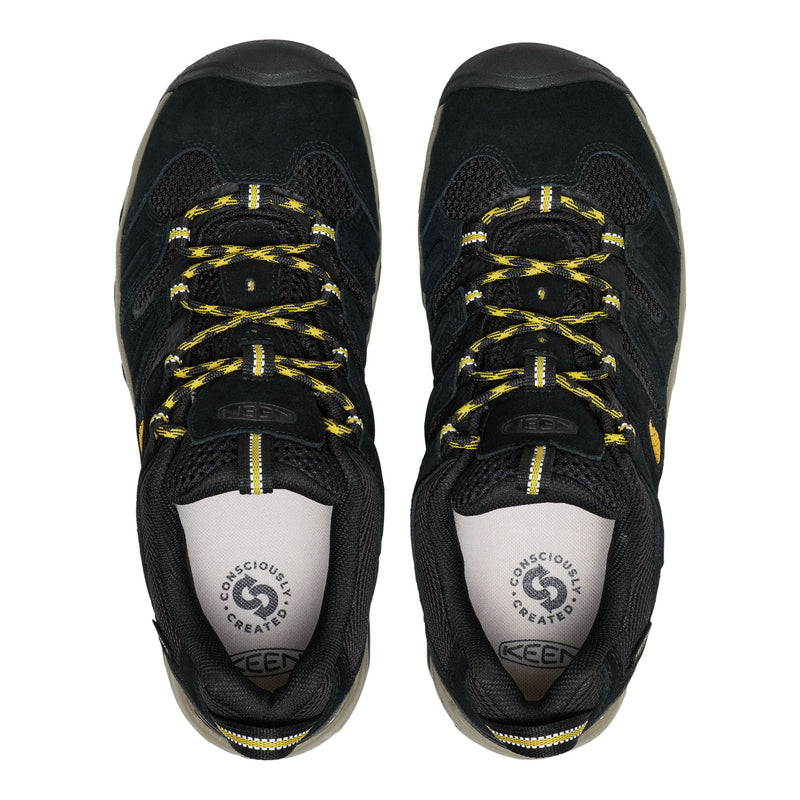 Black hiking shoes with yellow laces on a white background