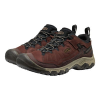 A pair of Keen hiking shoes in dark brown and black with a beige midsole, shown on a plain white background.