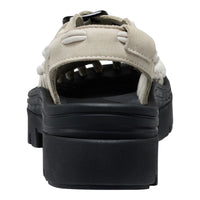 Black sandal with beige suede straps on a white background