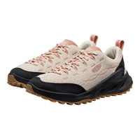 Pair of beige and black sneakers with pink accents on a white background