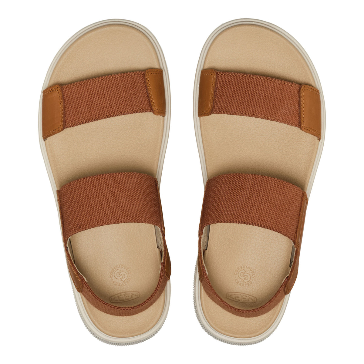 Pair of beige sandals with brown straps on a white background