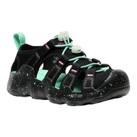 Black children's sandals with green straps on a white background