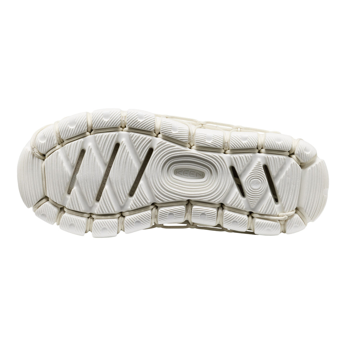 The textured white rubber outsole of a shoe, showing detailed tread patterns and grooves, isolated on a white background.