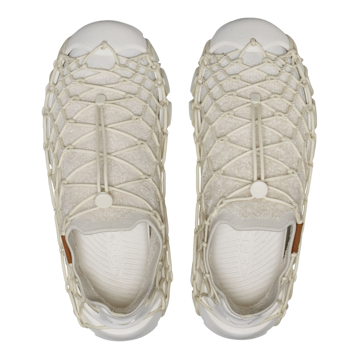 A pair of slip-on mesh sneakers with a thick, knotted off-white rope overlay, shown from a top-down view on a white background.