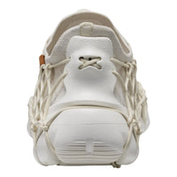 A close-up of a white sneaker featuring a unique web-like lace design wrapping around the sides and tongue, set against a plain white background.
