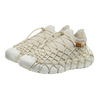 White shoe with woven design on a white background