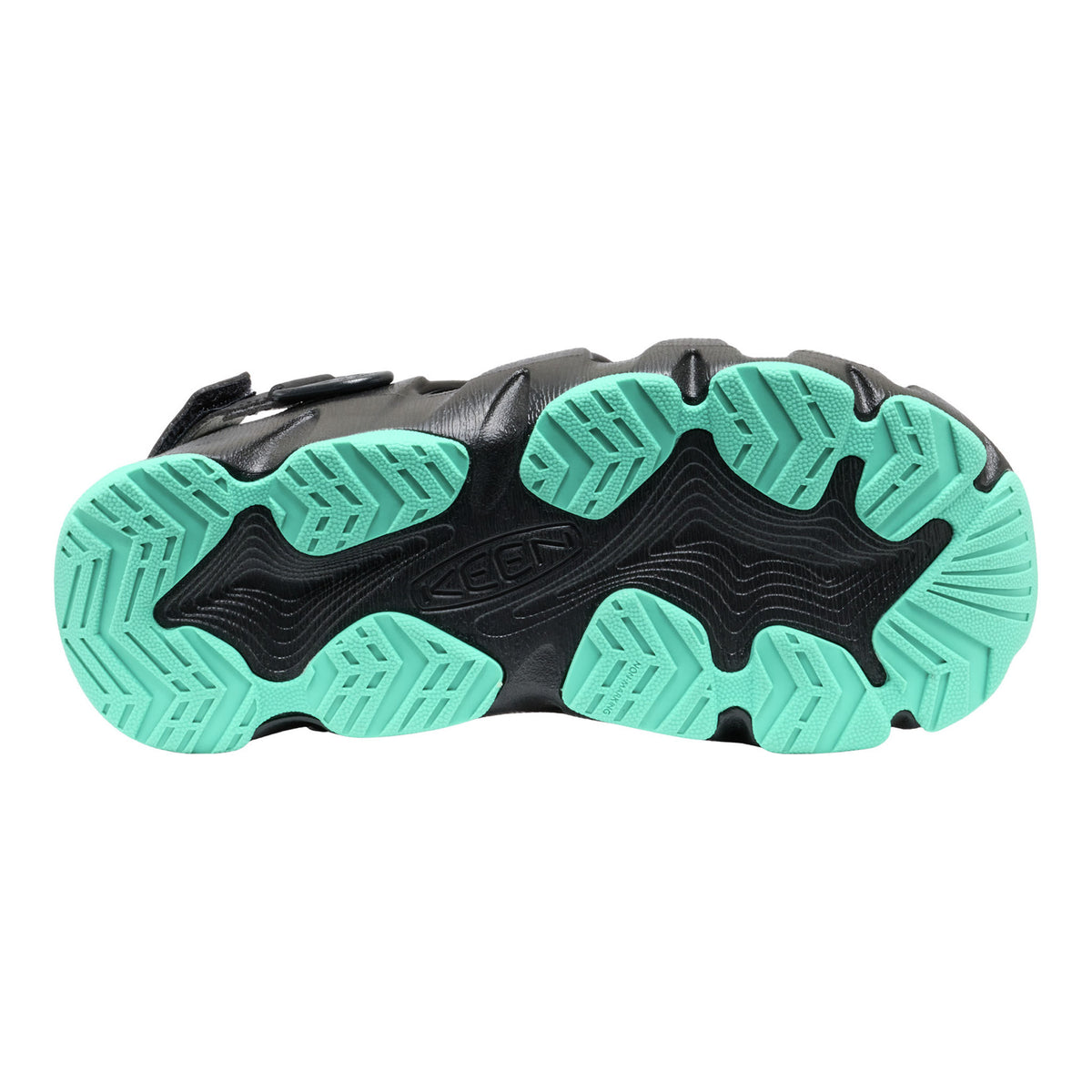 Close-up of a shoe sole with green and black tread pattern on a white background