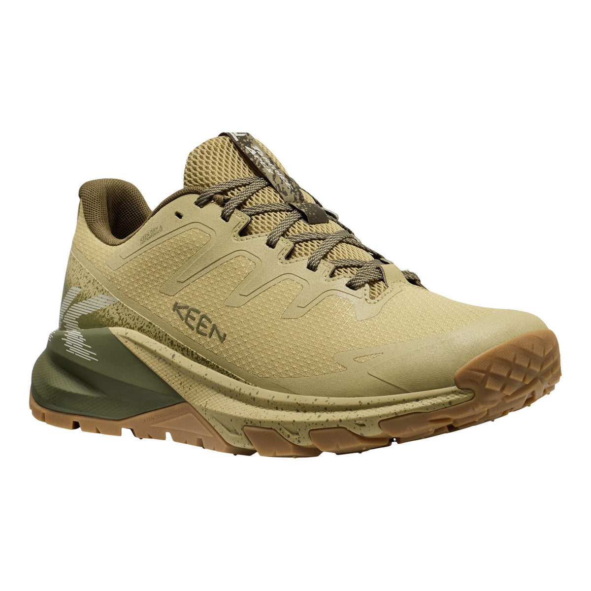 A Keen trail running shoe in a desert sand colorway, featuring a textured mesh upper, tonal laces, a dark olive green midsole section, and a brown outsole, shown against a plain white background.