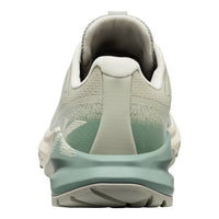 Back view of a light gray and green athletic shoe on a white background