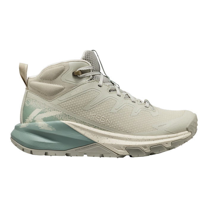 A mid-cut hiking boot by Keen, shown in profile against a solid white background. The boot features a light beige and off-white upper with a textured mesh pattern, a matching beige laces system, a prominent sage green and off-white midsole, and a rugged off-white outsole.
