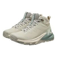 A pair of KEEN mid-top hiking shoes in a light beige and sage green colorway, shown from a three-quarters angle on a white background.