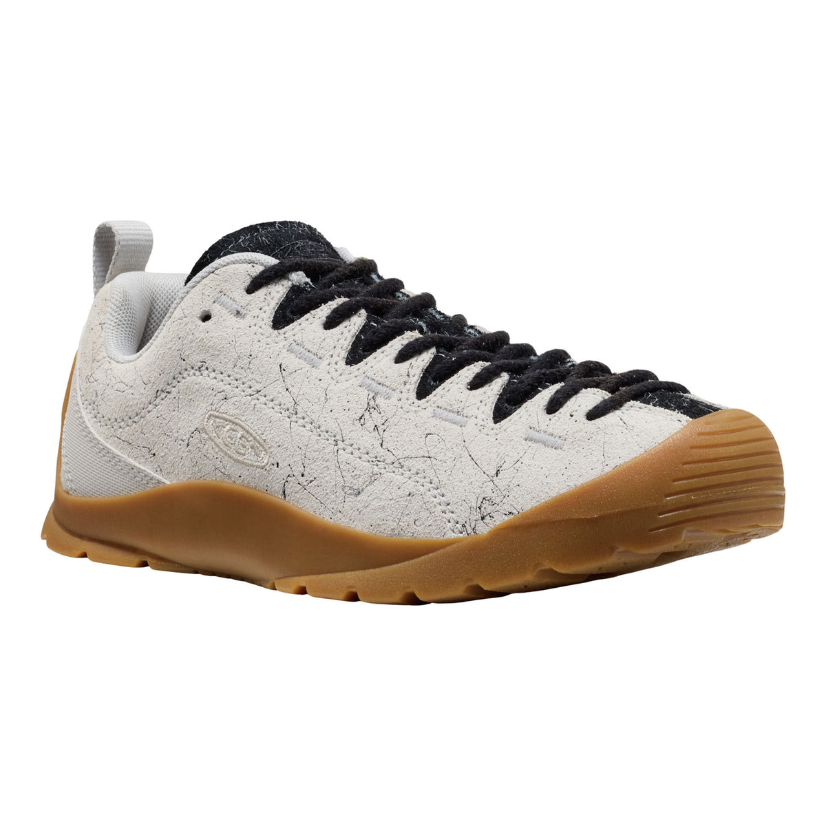 White sneaker with black laces and brown sole on a white background
