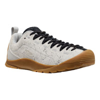 White sneaker with black laces and brown sole on a white background
