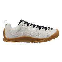 White sneaker with black laces and brown sole on a white background