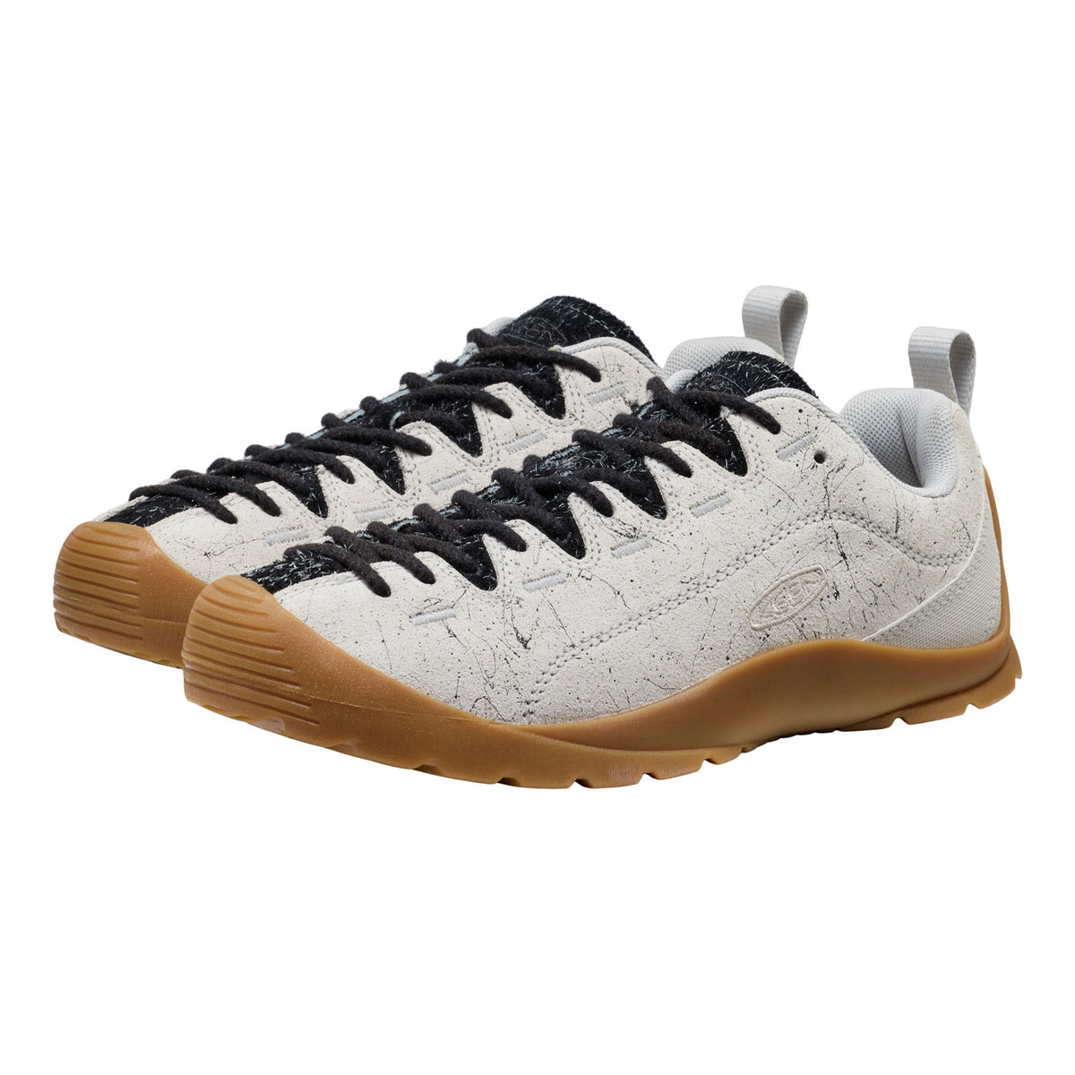 White sneakers with black laces and brown soles on a white background