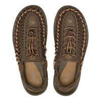Pair of brown sandals with braided details on a white background