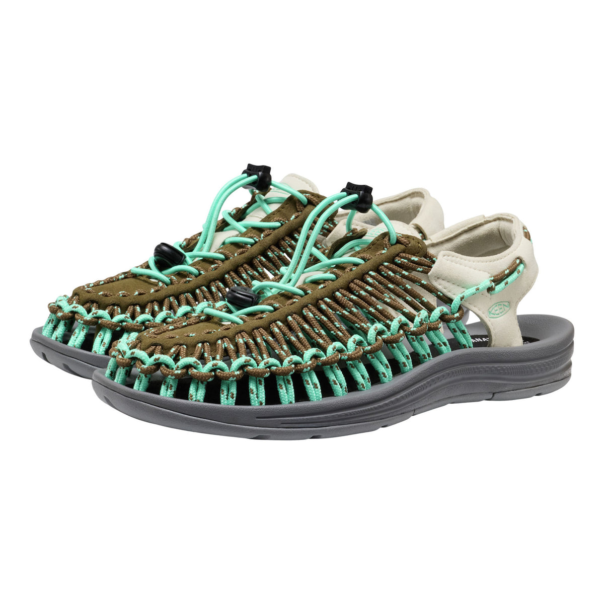 Pair of sandals with green straps and brown soles on a white background