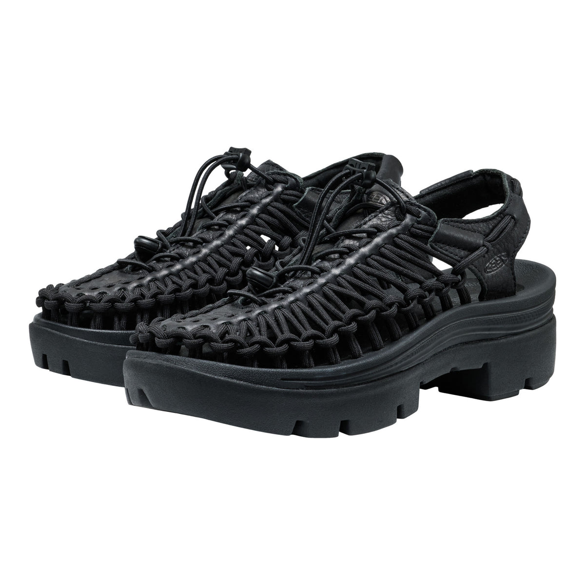 Black sandals with unique sole design on a white background