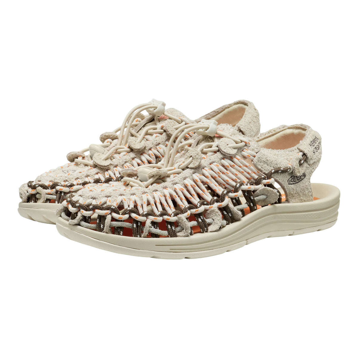 A pair of woven open-toe sandals with a chunky beige sole, featuring a textured knit upper in beige, brown, and orange tones, shown on a plain white background.