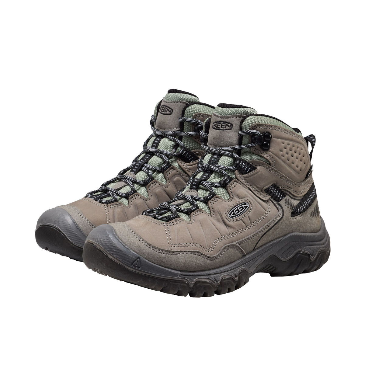 Pair of beige hiking boots with black soles on a white background