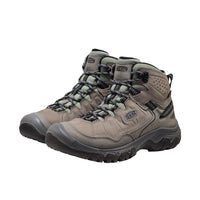 Pair of beige hiking boots with black soles on a white background