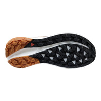 Close-up of a shoe sole with brown, black, and white tread pattern on a white background