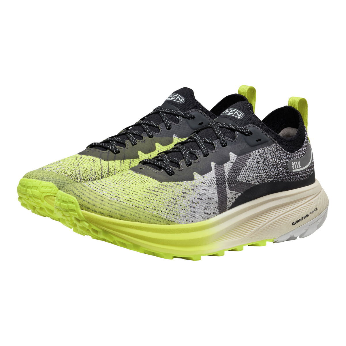 Pair of running shoes with bright green soles on a white background