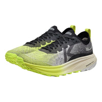 Pair of running shoes with bright green soles on a white background