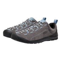A pair of Keen outdoor shoes in grey suede and black rubber, featuring light blue accents on the laces, stitching, and heel pull tabs, shown against a plain white background.