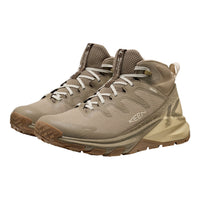 A pair of KEEN mid-top hiking boots in a desert sand colorway, featuring a textured mesh upper, lace-up front, and rugged sole, shown against a plain white background.