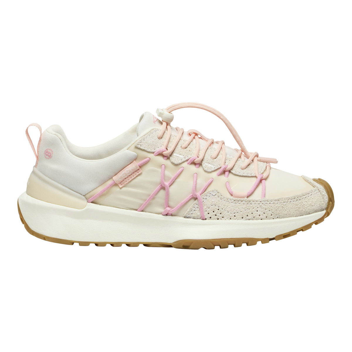 A low-top sneaker in off-white and light pink, featuring textured mesh and suede panels, pink laces, and a gum-colored outsole, shown from a side profile on a white background.