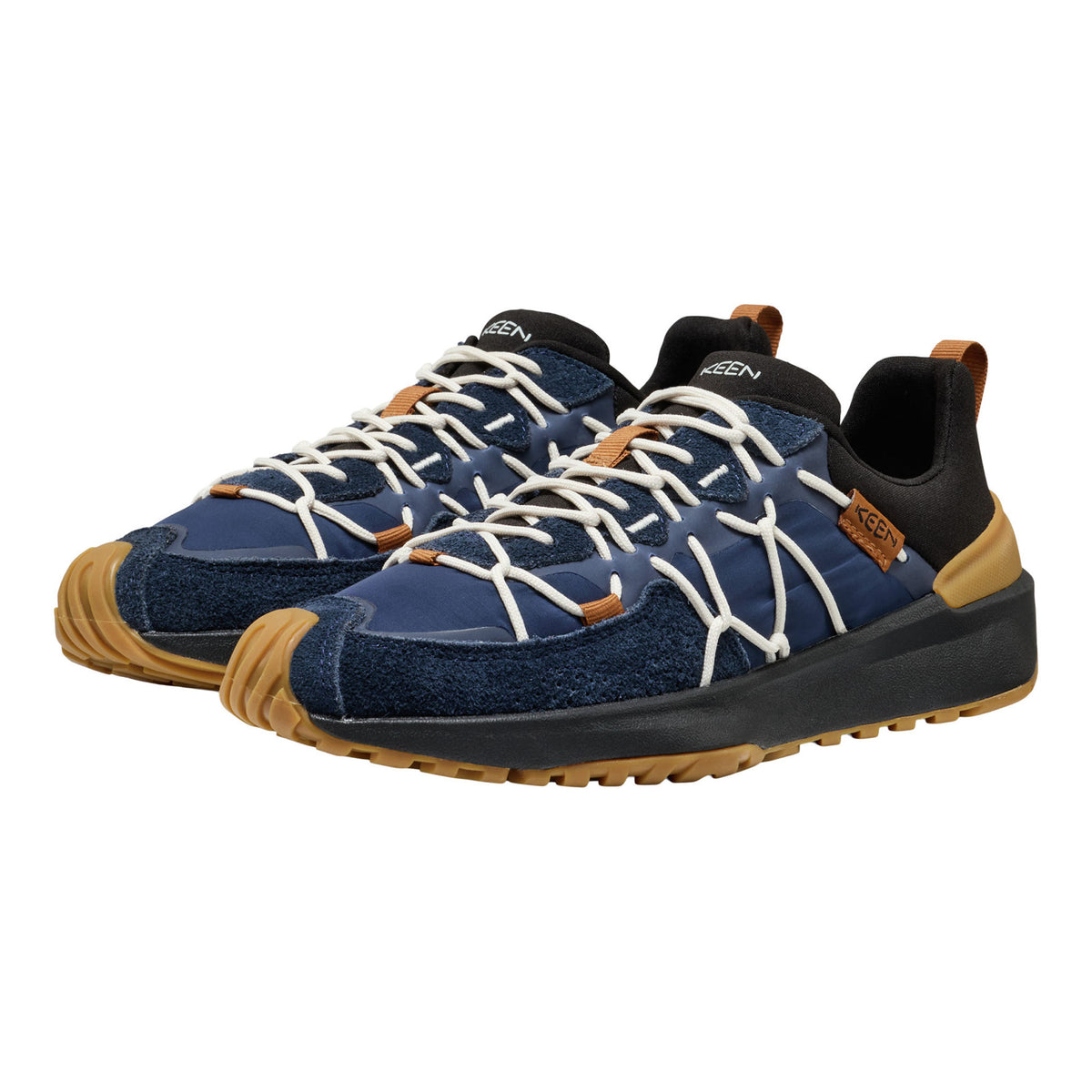A pair of outdoor sneakers in navy blue suede and mesh, featuring white laces, black collar lining, tan rubber toe caps and heel accents, and a black and tan sole, shown against a plain white background.