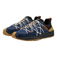 A pair of outdoor sneakers in navy blue suede and mesh, featuring white laces, black collar lining, tan rubber toe caps and heel accents, and a black and tan sole, shown against a plain white background.