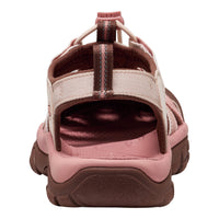 A women's hiking sandal shown from a rear three-quarter view, featuring a dusty pink footbed and midsole, dark brown textured outsole, and beige straps with dark brown accents.