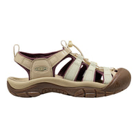A Keen brand women's sandal in beige and brown, featuring cream-colored laces and a dark brown protective toe cap, shown from a side profile on a white background.