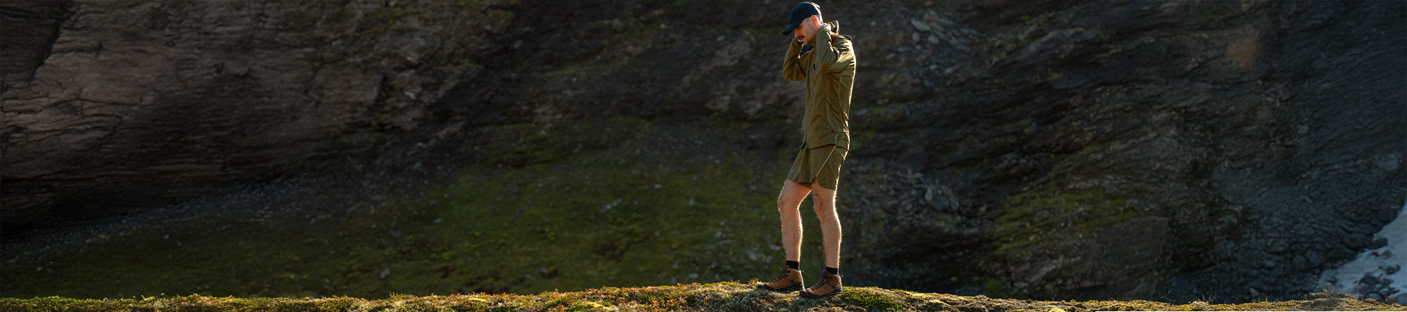 Person standing on a rocky outcrop with a scenic background