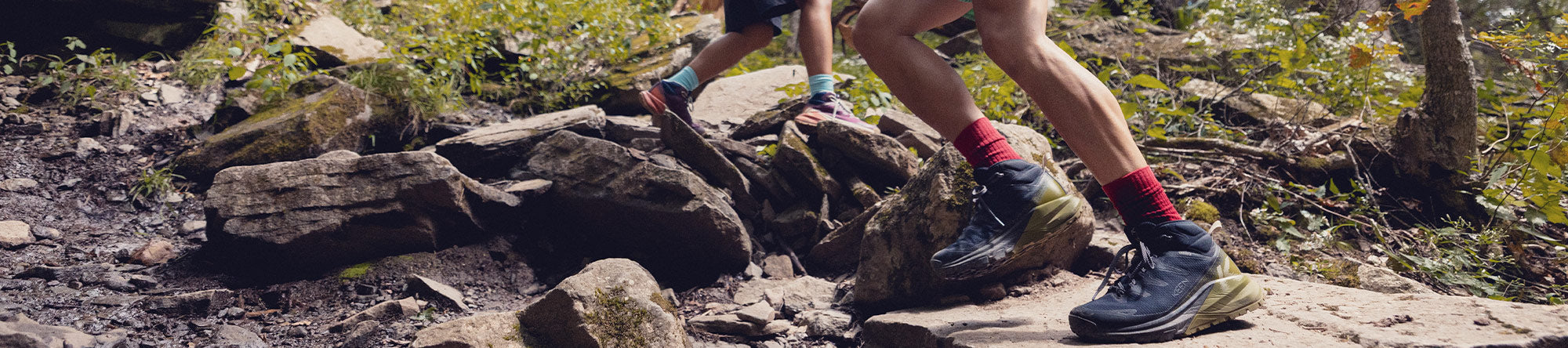 Person hiking on a rocky trail with colorful socks